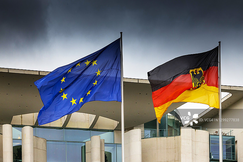 德国和欧盟旗帜与德国总理府及乌云图片素材
