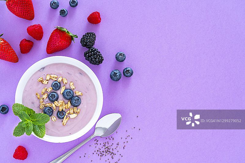 紫色背景上的浆果谷物酸奶俯视图图片素材