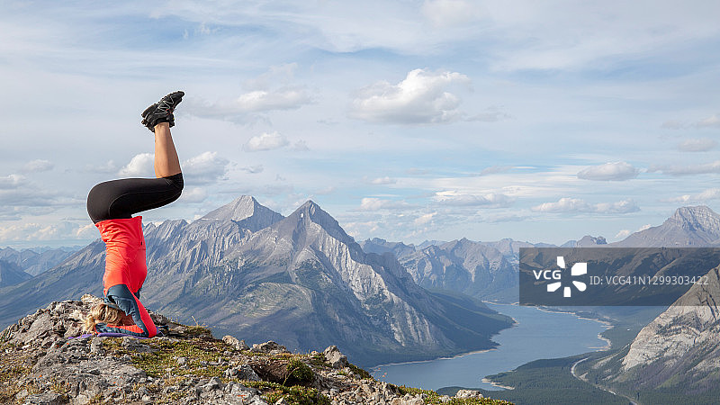 清晨，女徒步者在山脊上倒立图片素材
