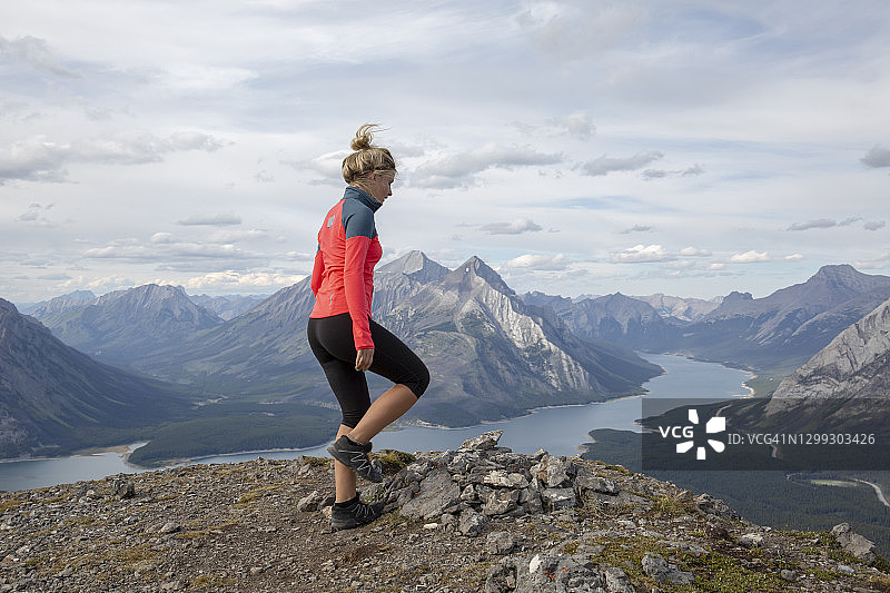在阳光明媚的山脊上放松的徒步女人图片素材