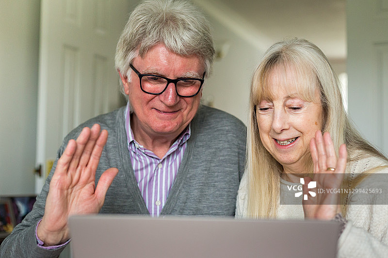 年长夫妇在家用笔记本电脑与家人视频通话图片素材