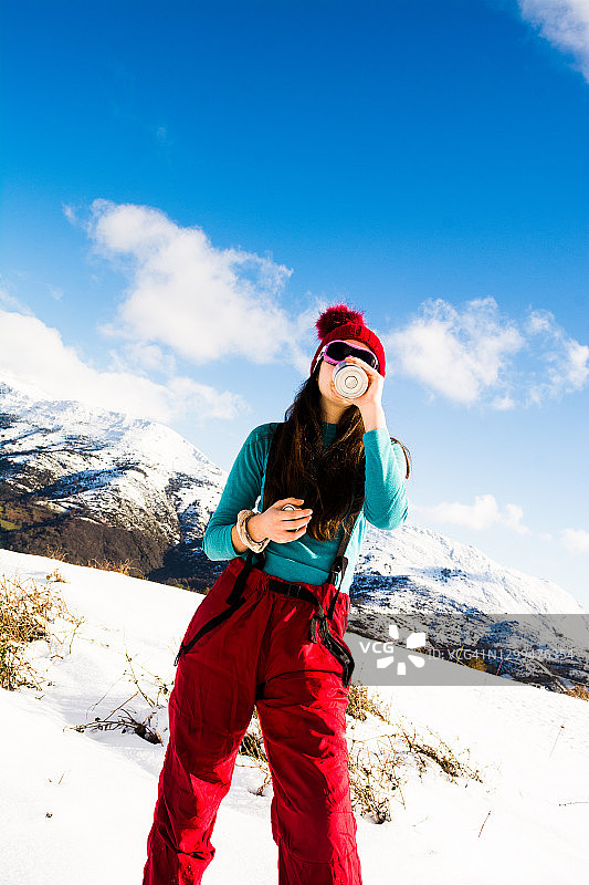 前景：在雪地里喝水的少女图片素材