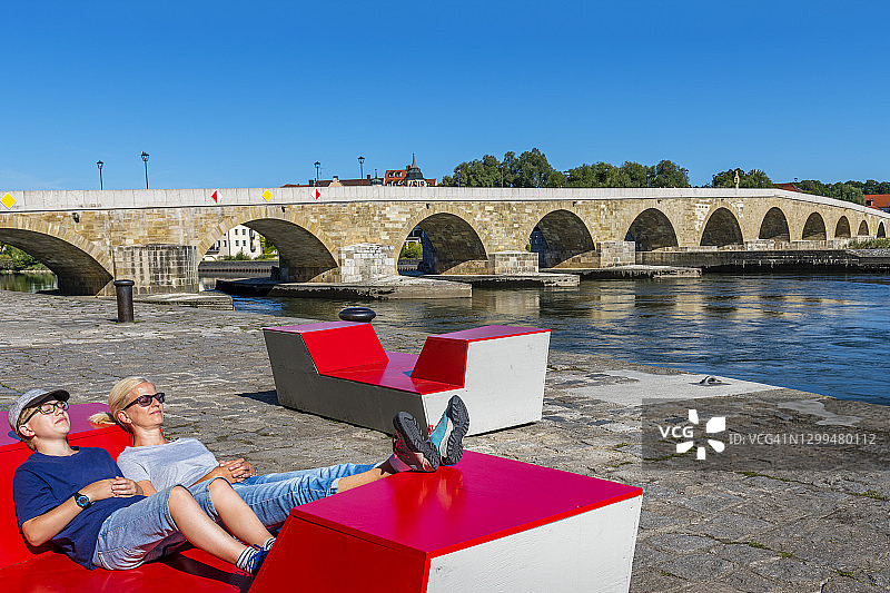 女人和儿子在雷根斯堡古石桥前休息图片素材