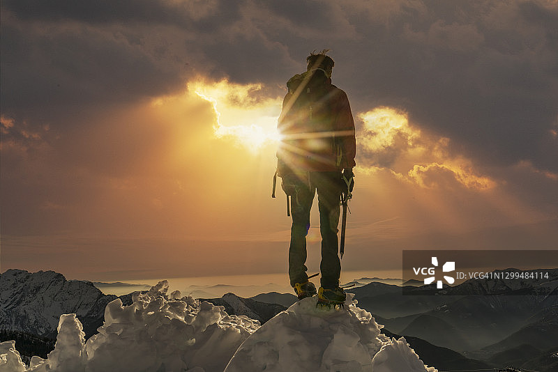 日出时分山顶上的登山者图片素材