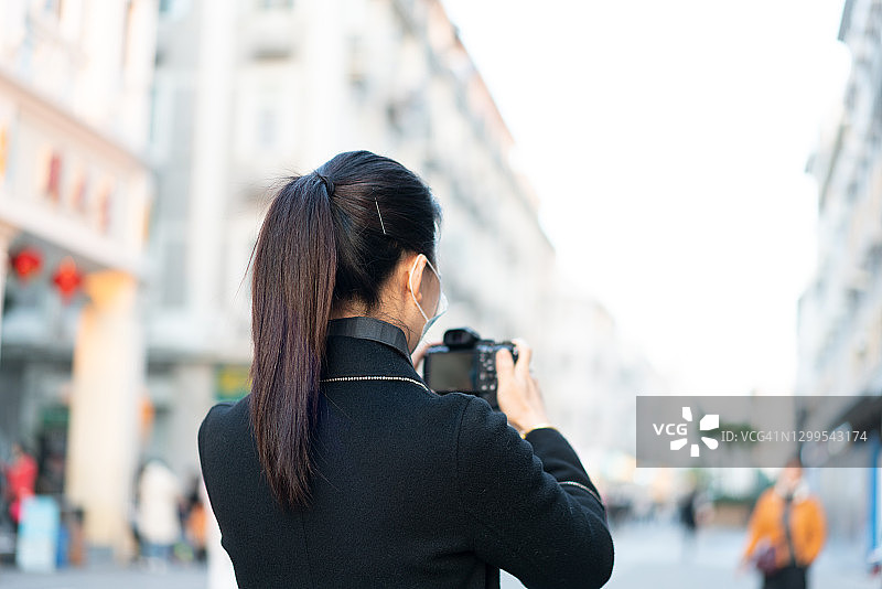 亚洲女性使用相机拍照图片素材