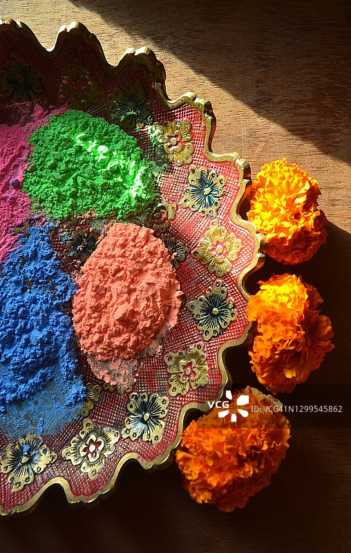 洒红节：黄铜盘中的彩色粉末和万寿菊花图片素材