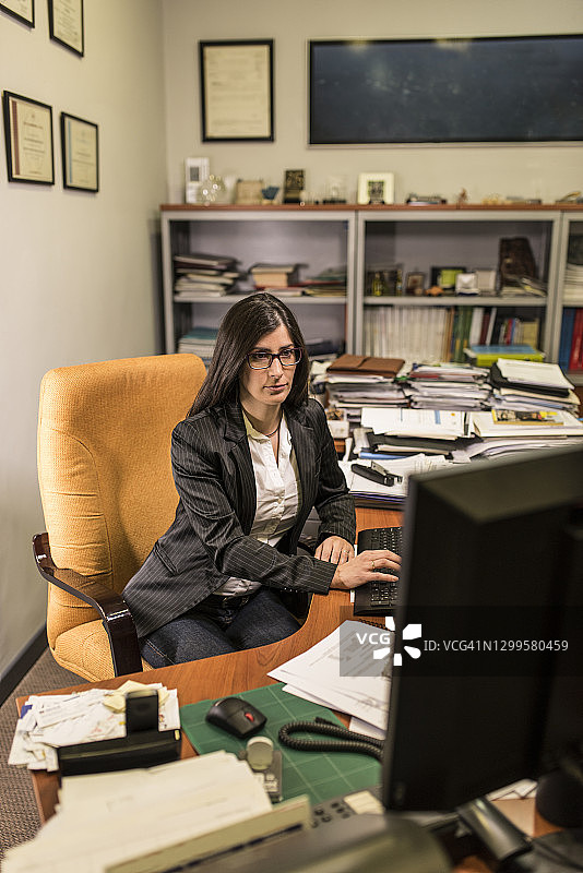 30岁女子深夜在办公室电脑前工作图片素材