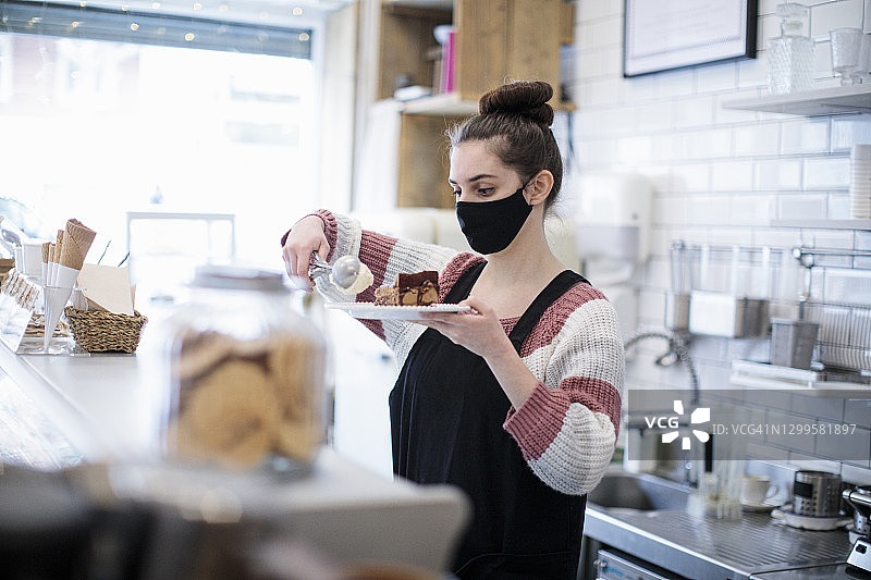 咖啡店里戴着口罩的年轻女服务员图片素材