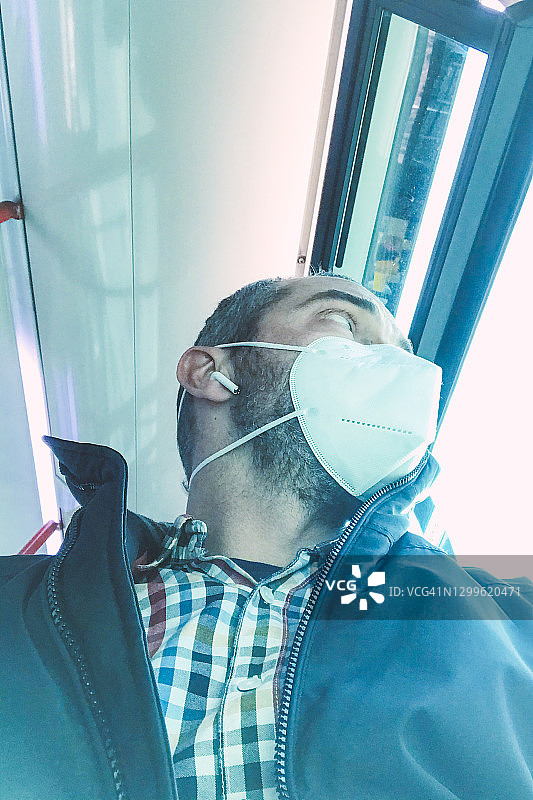 戴口罩乘坐公交车的男子肖像图片素材