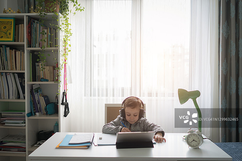 戴着耳机在电脑上在线学习的儿童图片素材