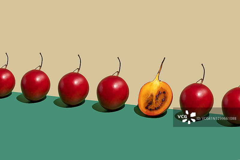 重复的树番茄和半个水果在绿米色背景上图片素材