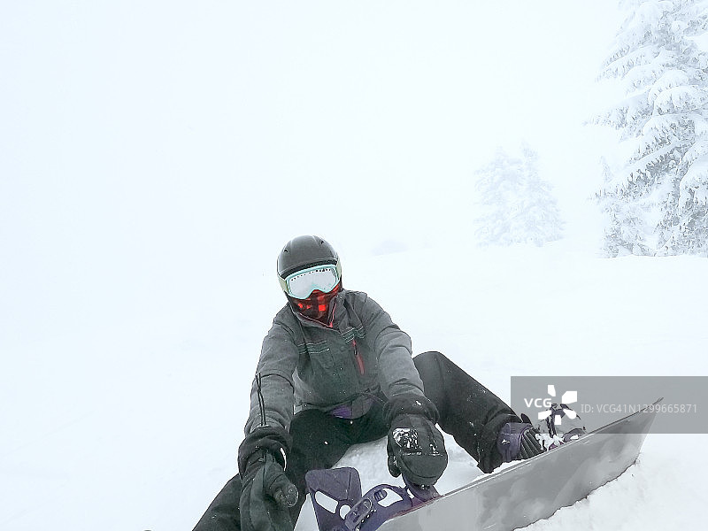 戴脖套的女人在滑雪场固定滑雪板图片素材