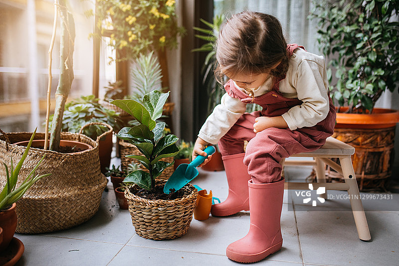 可爱女孩在阳台种花图片素材