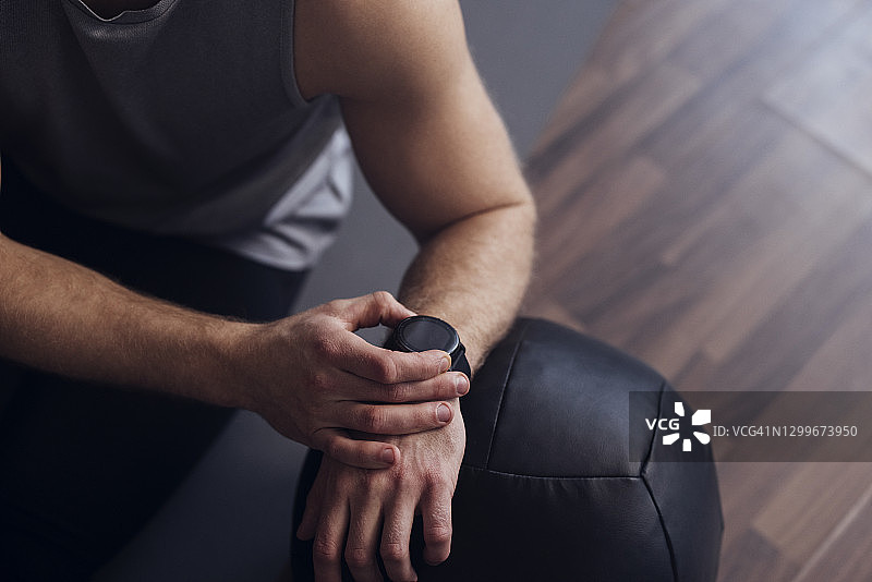 年轻的运动员用智能手表测量脉搏图片素材