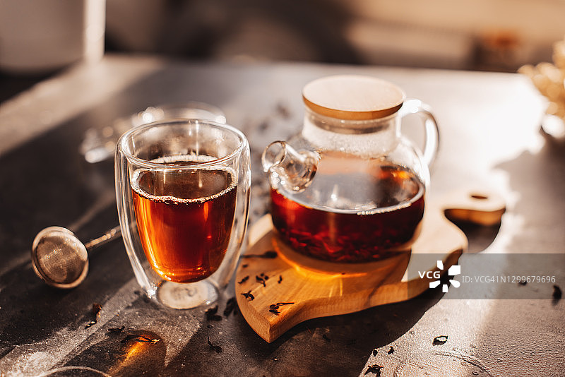 茶冲泡流程：茶道，一杯新鲜的红茶，温暖柔和的光线，深色背景图片素材