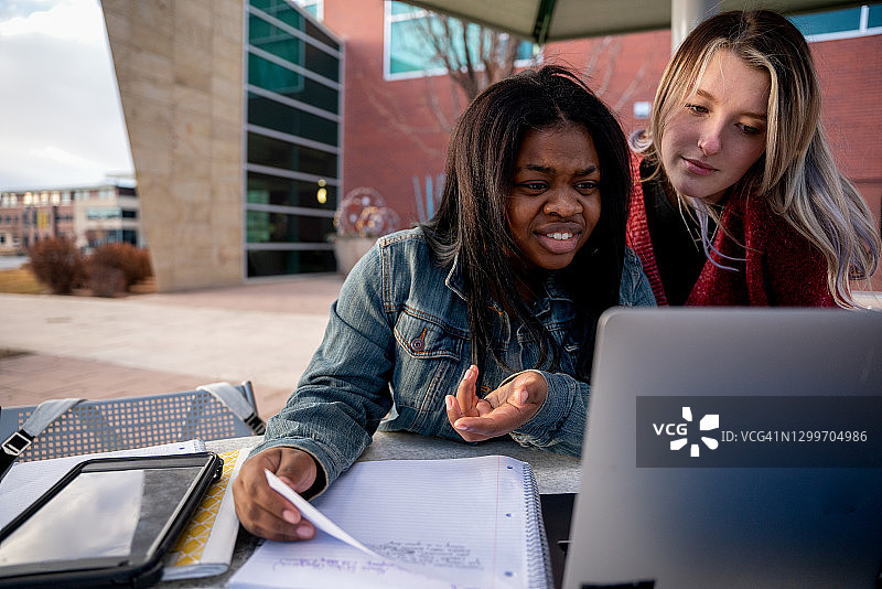大学生帮助苦恼的朋友解决课堂问题图片素材