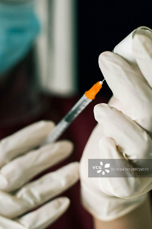 身穿防护服、戴手套、口罩和面罩的医护人员正在准备冠状病毒疫苗接种图片素材