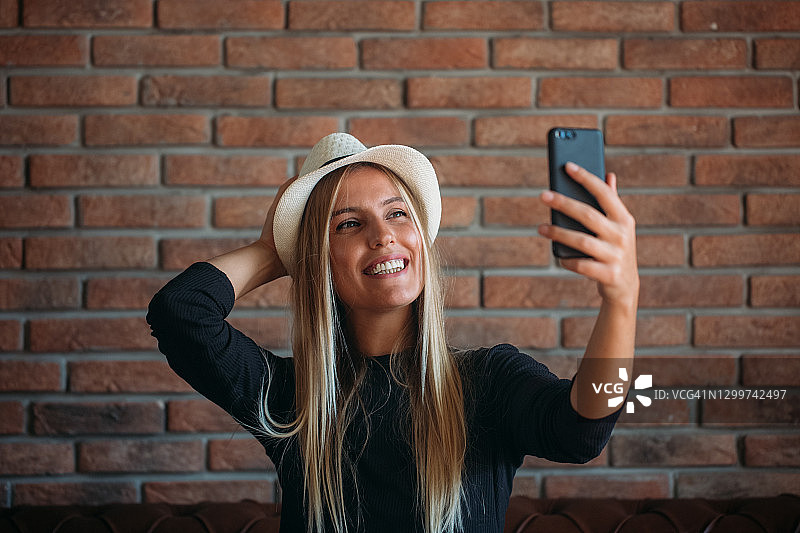 在咖啡馆自拍的可爱年轻女人图片素材