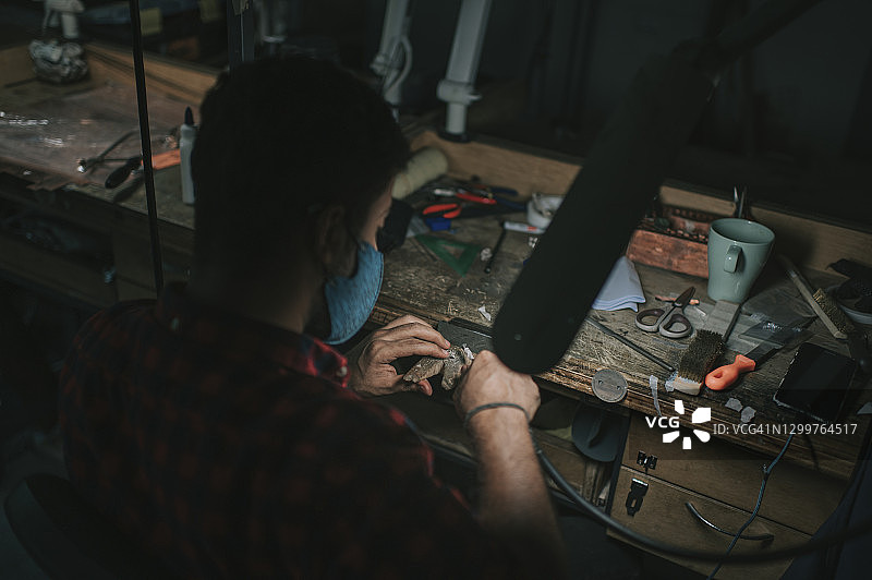 俯视中东男性手工艺学生大学工作台打磨珠宝图片素材