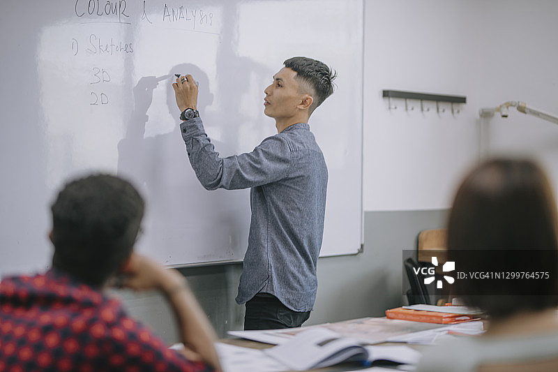 马来西亚籍男讲师在课堂上给学生讲授珠宝设计课图片素材