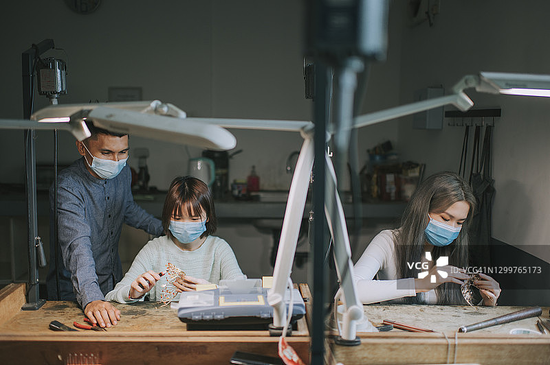 马来西亚珠宝工艺设计讲师在学院教育课堂上指导女学生的设计图片素材
