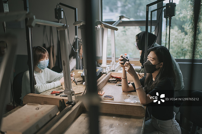 四个亚洲女大学生在工作台上并排制作珠宝设计图片素材