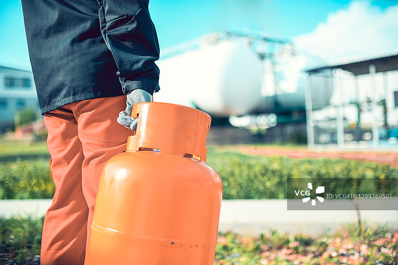 在外面扛着煤气罐去充气的男人图片素材