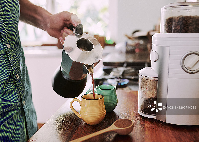 年轻男人用摩卡壶煮咖啡的厨房场景图片素材