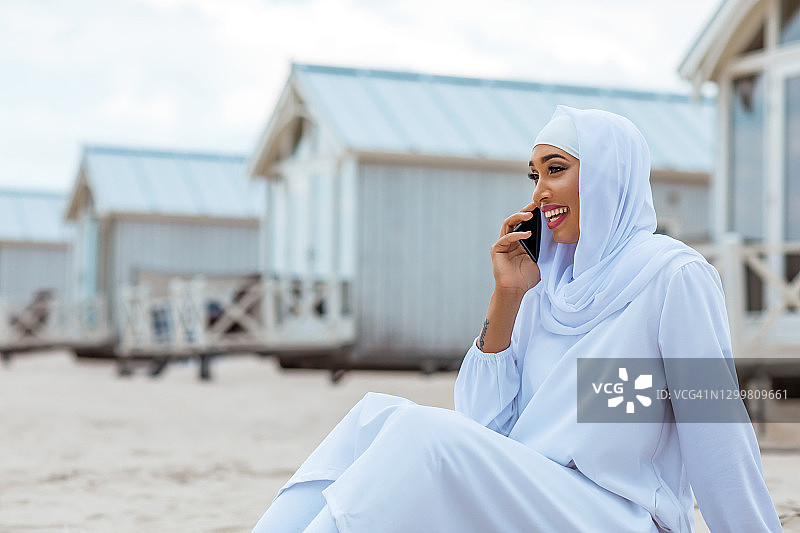 在海滩上戴着头巾的美丽穆斯林妇女图片素材