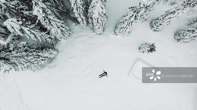 男子在雪地制作天使的航拍景观图片素材