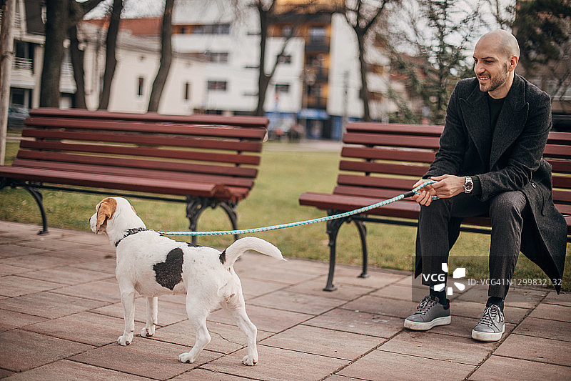 男人和他的狗在公园里图片素材