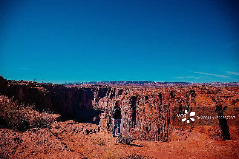 男人看着沙漠中的峡谷图片素材