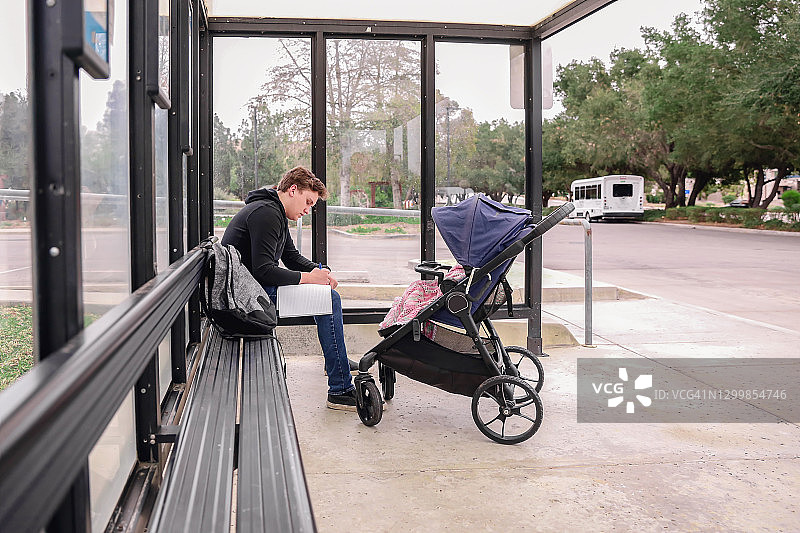 在公共汽车站带着婴儿车的男大学生图片素材
