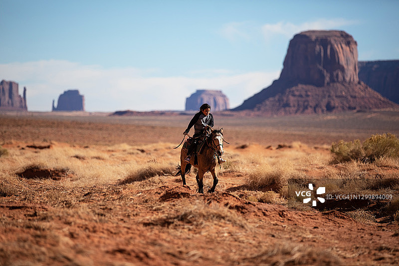 在纪念碑谷骑马的纳瓦霍族孩子图片素材