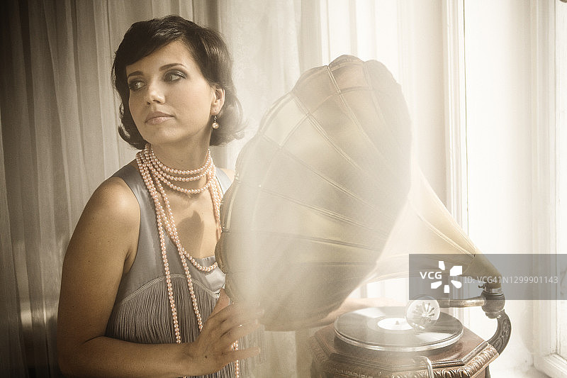 拥有20年代风格，与留声机合影的女人图片素材