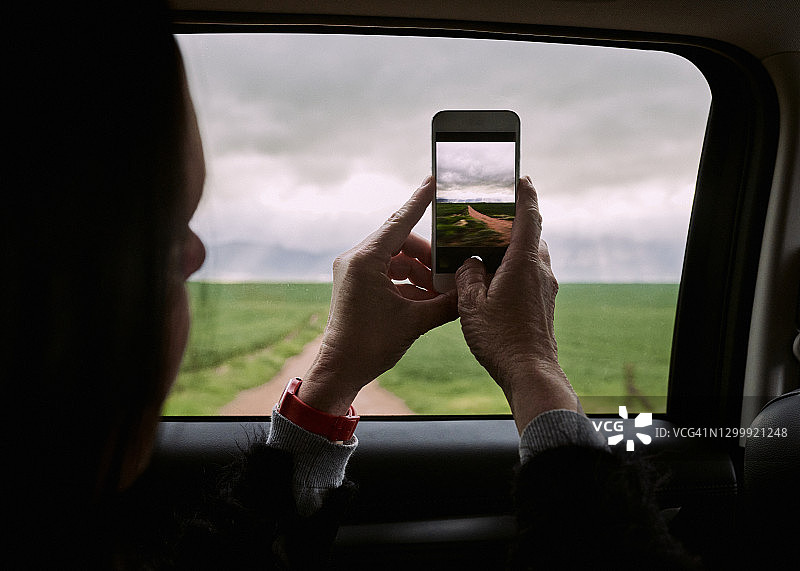 女人在车窗边用手机拍摄风景图片素材