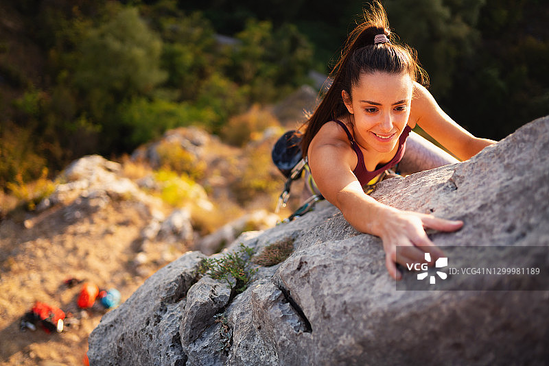 笑容满面的健壮女人在野外攀岩图片素材