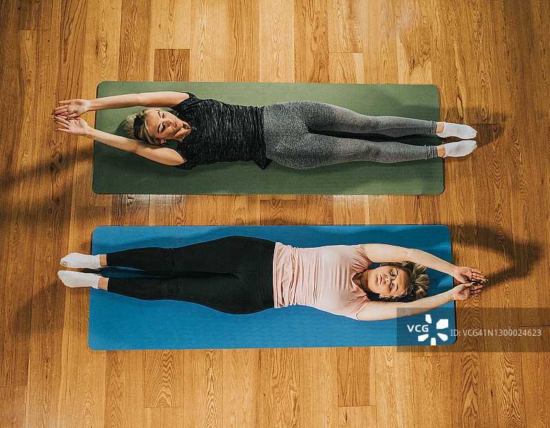 两名女性在瑜伽垫上做仰卧起坐的俯视图像图片素材