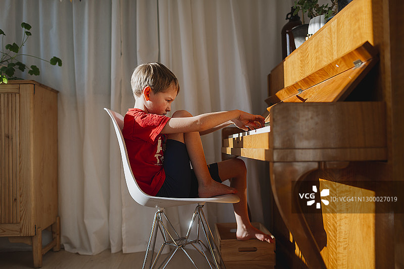 男孩弹钢琴图片素材