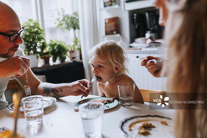 父亲在餐桌旁喂幼儿图片素材