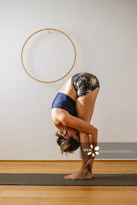 30岁出头的女人做站立前屈的肖像图片素材