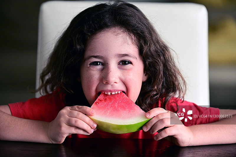 吃冰镇西瓜的卷发小女孩图片素材