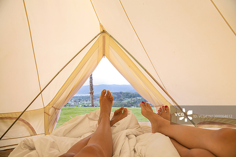 东南亚女子在豪华帐篷内放松，可欣赏户外美景图片素材