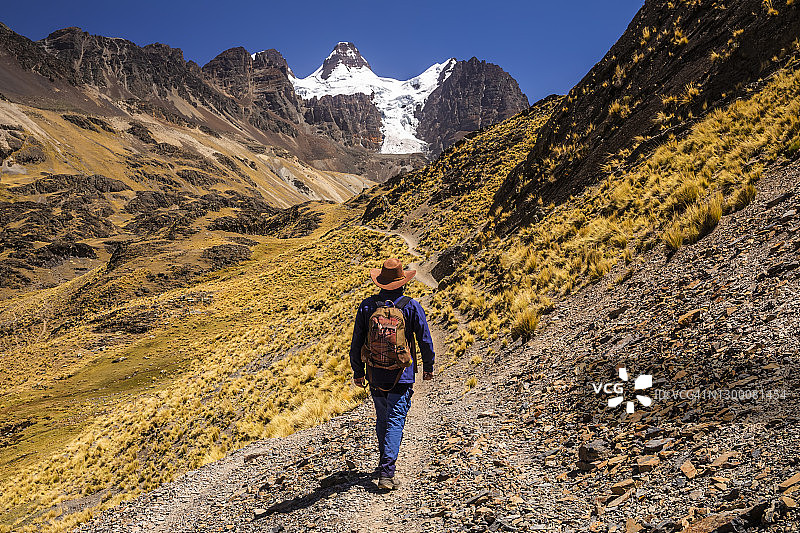 徒步者背着背包走在通往玻利维亚安第斯山脉科迪勒拉Real的秃鹰峰和湖泊的小路上图片素材