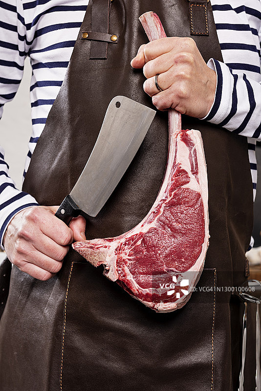 厨师拿着巨大的T骨牛排和肉刀图片素材