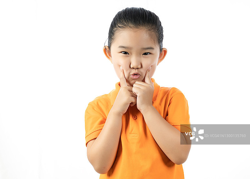 在白色背景前做可爱表情的女孩图片素材