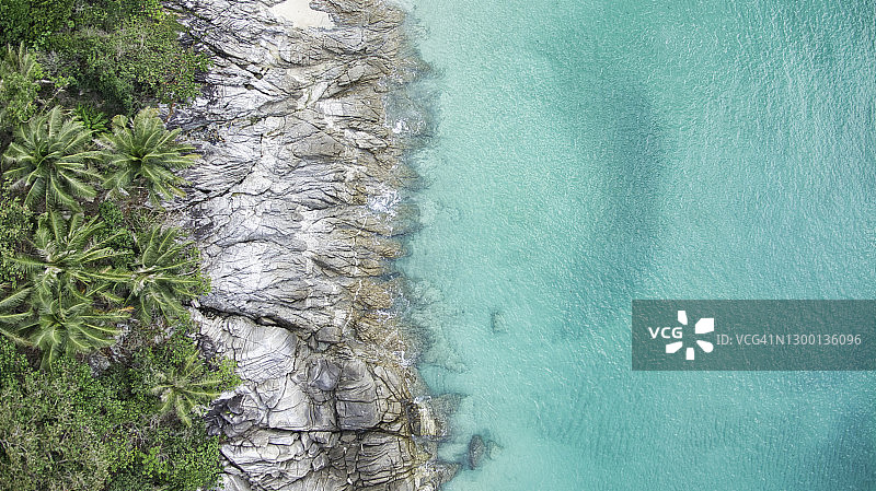 泰国普吉岛的岩石海滩和清澈的海水与椰子树图片素材