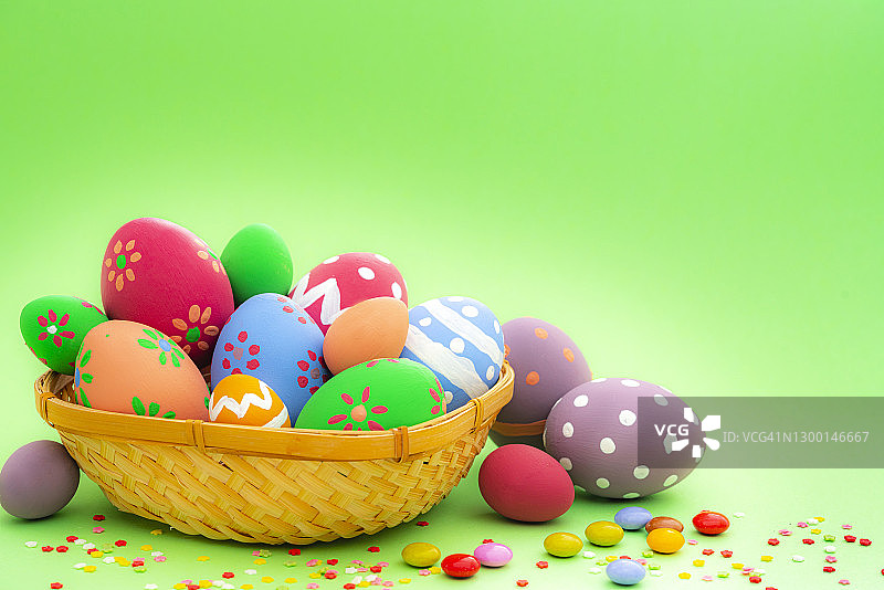 绿色背景上带有糖果和糖屑的彩色复活节彩蛋，留白图片素材