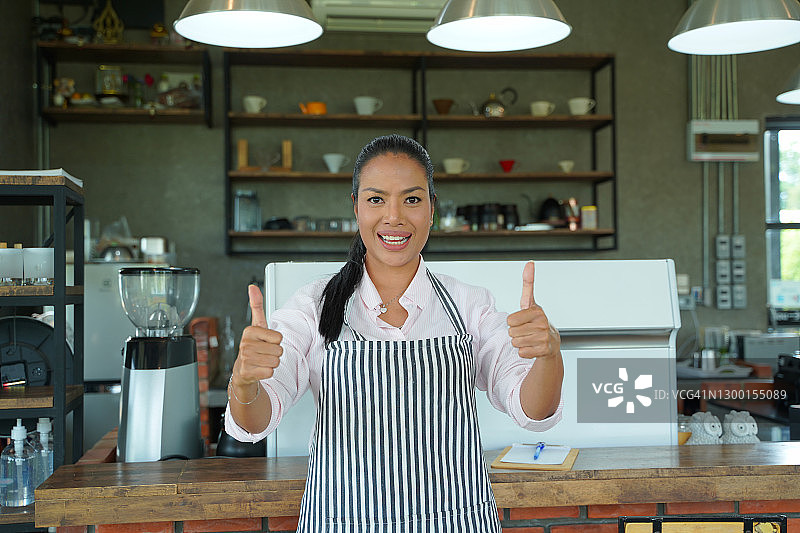 咖啡店里一位女服务员竖起大拇指的肖像图片素材