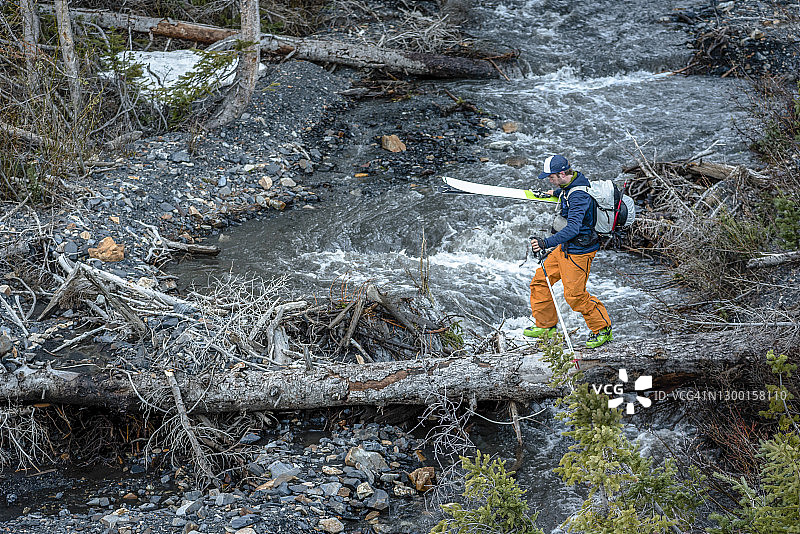 滑雪登山者在山区原木上过河图片素材